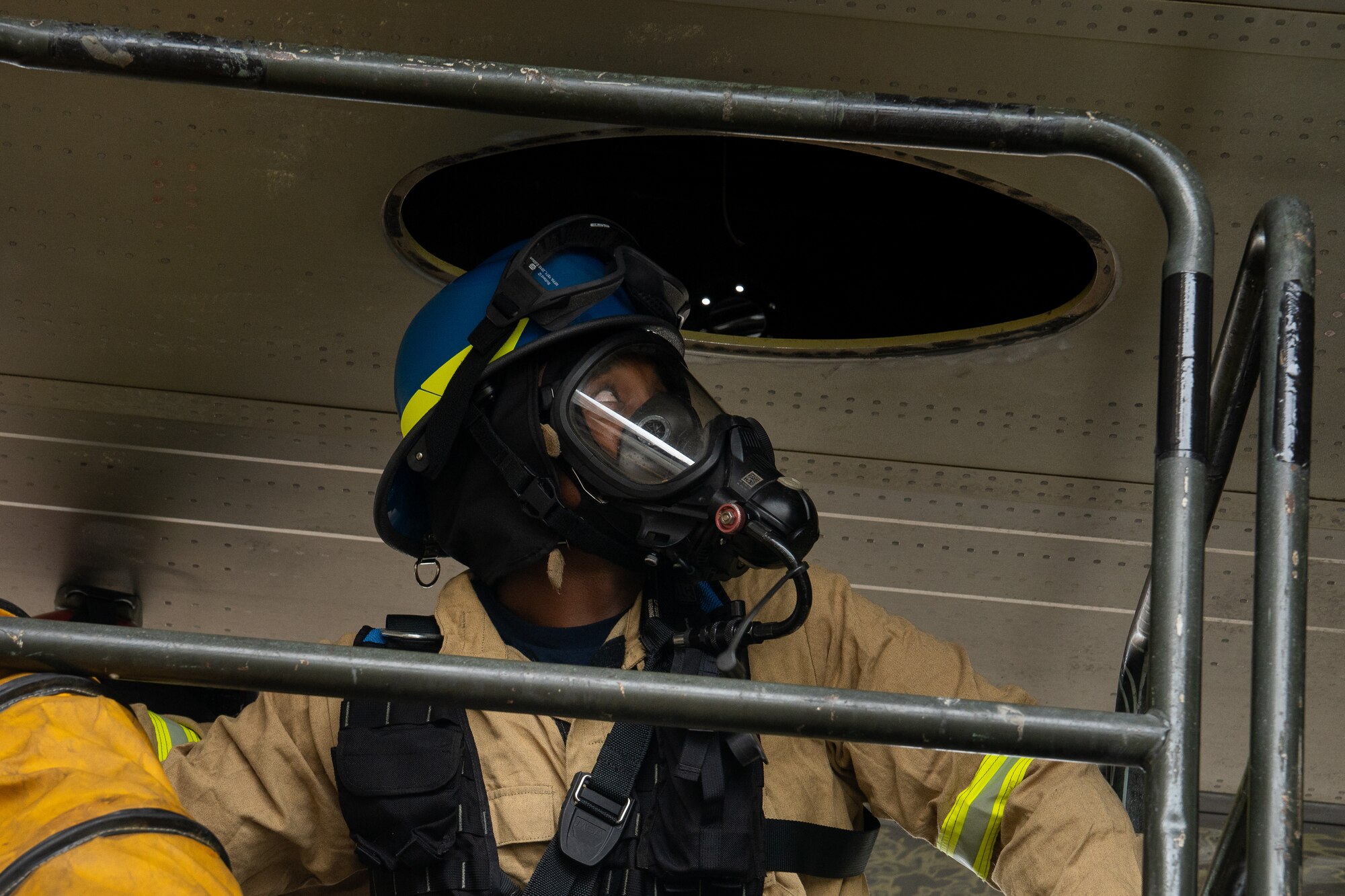 Firefighters retrieve a mannequin from a confined space in a C-130 wing cavity