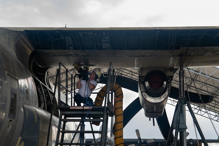 Firefighters retrieve a mannequin from a confined space in a C-130 wing cavity