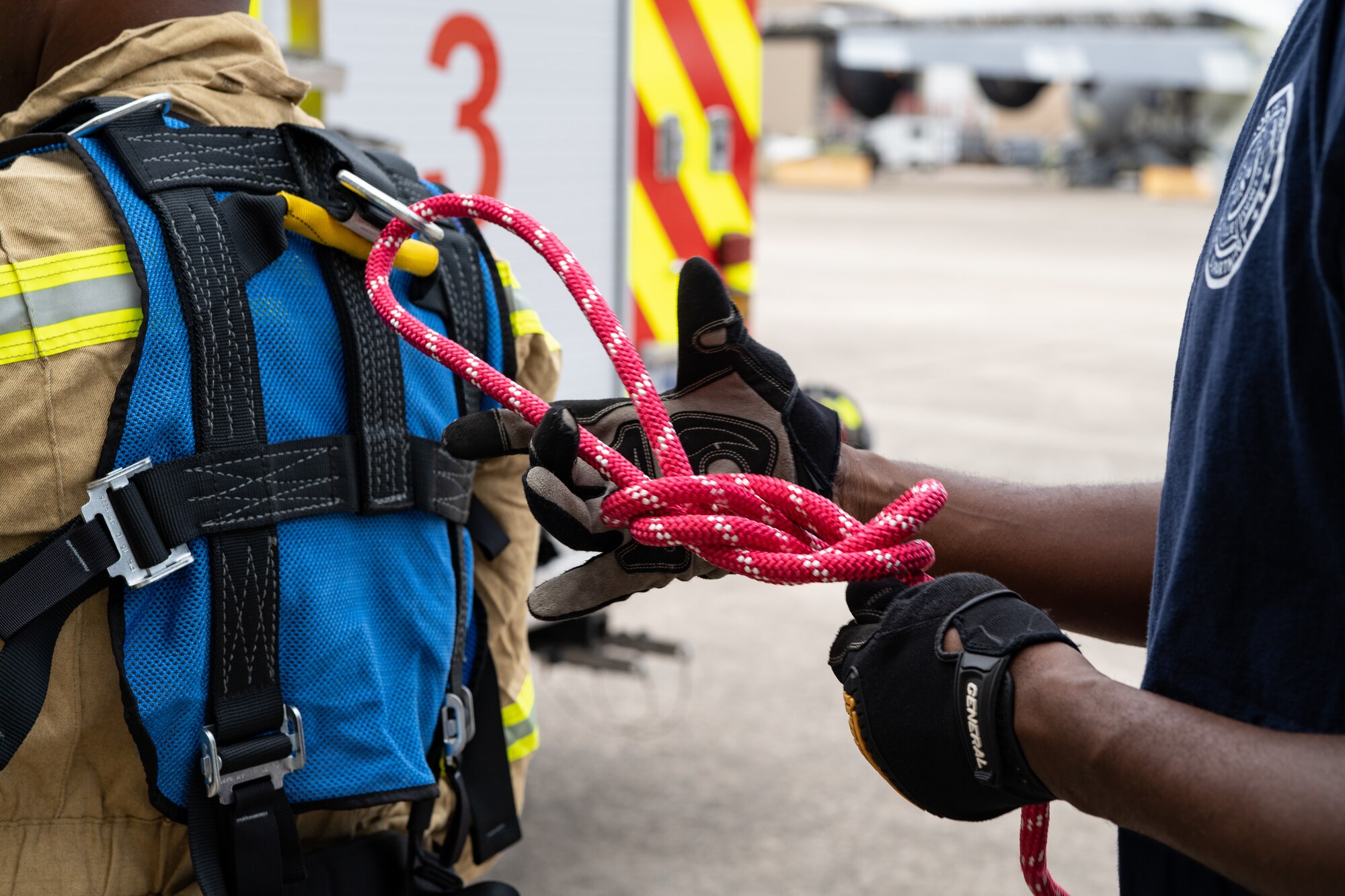 Firefighters tie knots to rig a harness