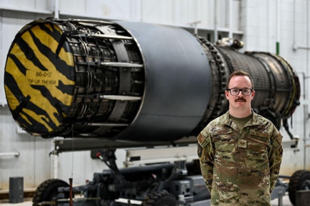 U.S. Air Force Staff Sgt. Garry Moore, 37th Bomber Generation Squadron aerospace propulsion craftsman, poses beside a B-1B Lancer jet engine during exercise Raider Reach 2024 at Ellsworth Air Force Base, S.D., Sept. 17.
