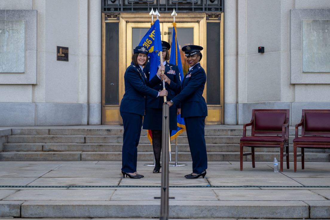 Lt. Col. FaLana Gideon, right, incoming 316th Inpatient Squadron commander, receives the 316th IPTS guidon from U.S. Air Force Col. Stacy Freisen.