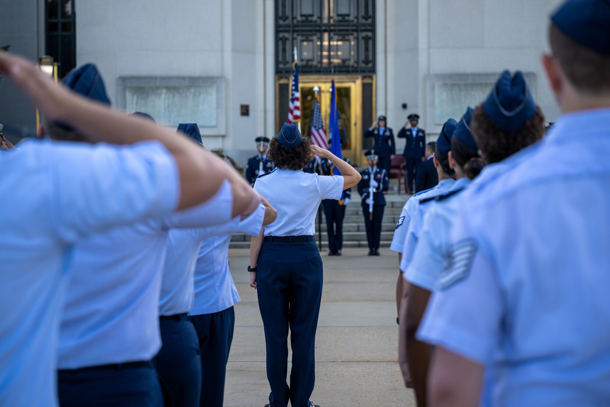 Airmen salute the U.S. flag.