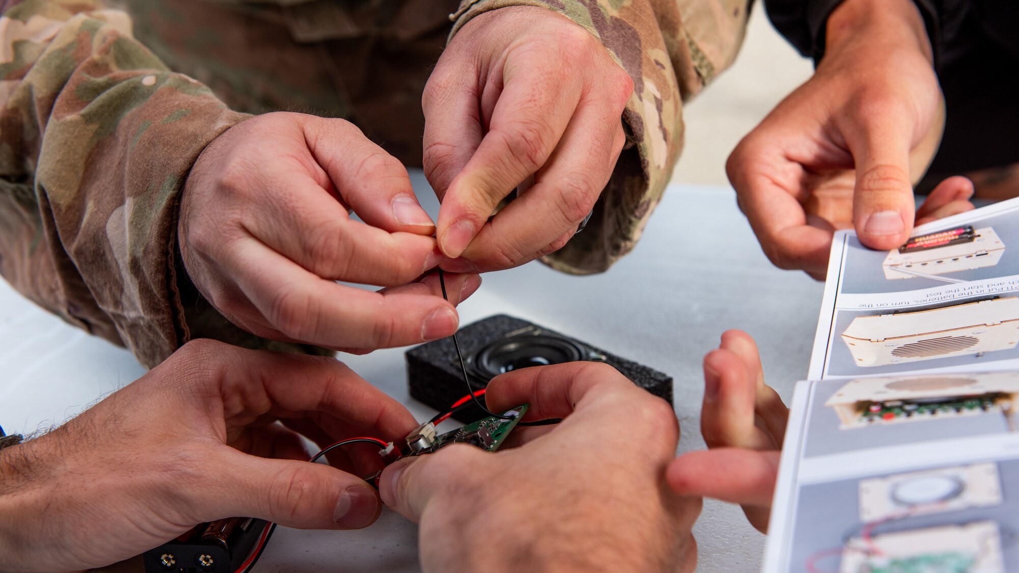 Close-up of hands building a radio.