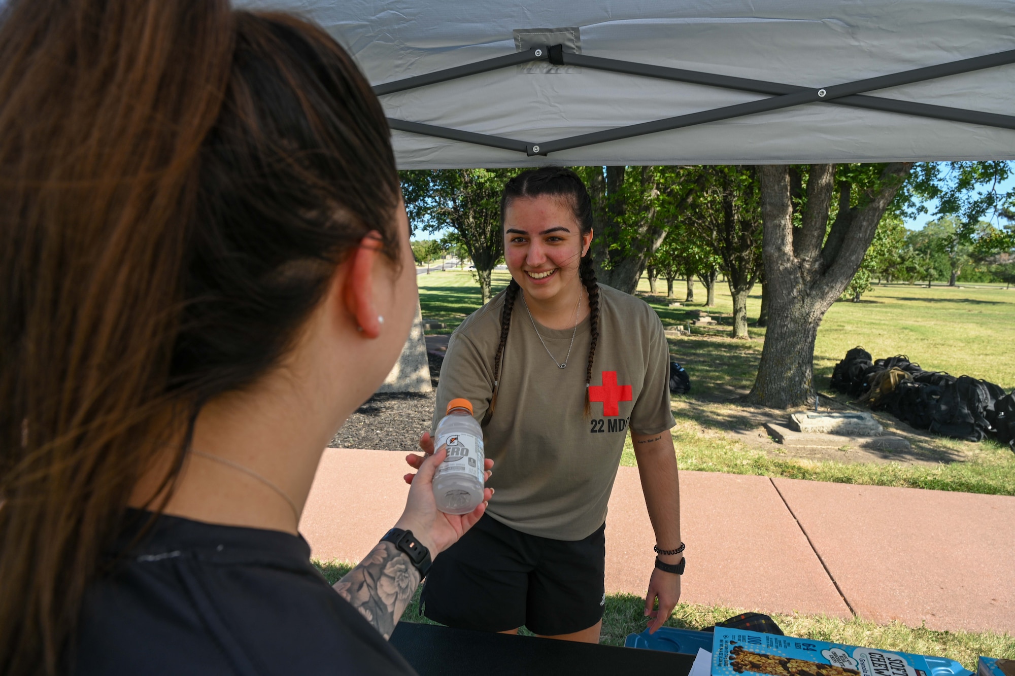 Senior Airman Raquel Kos, 22nd Medical Group medical technician, hands out beverages during the POW/MIA remembrance week 24-hour vigil walk/run Sept 18, 2024, at McConnell Air Force Base, Kansas. The week honors more than 81,500 U.S. service members who remain unaccounted for. (U.S. Air Force photo by Senior Airman William Lunn)