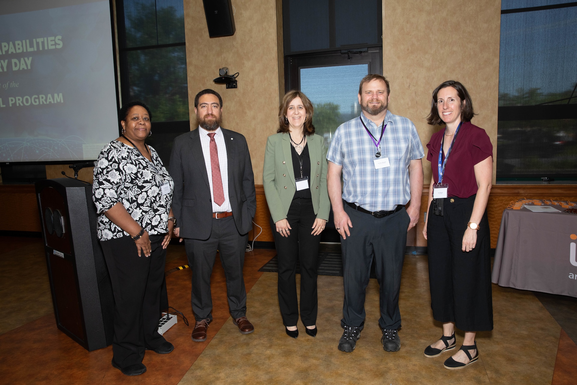 Five staff members stand together for a photo in business attire