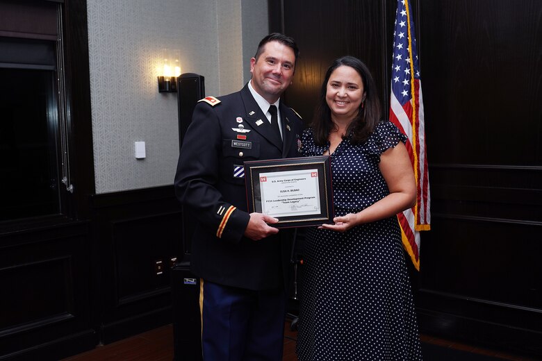 Maj. Matt Westcott Jacksonville District Deputy commander presents Elisa Bilbao, a civil engineer her Leadership Development Program Course graduation certificate during a ceremony Sept. 12, 2024, at Maggiano's Little Italy in Jacksonville’s Town Center in Jacksonville, Fla. (USACE Photo by Mark Rankin)