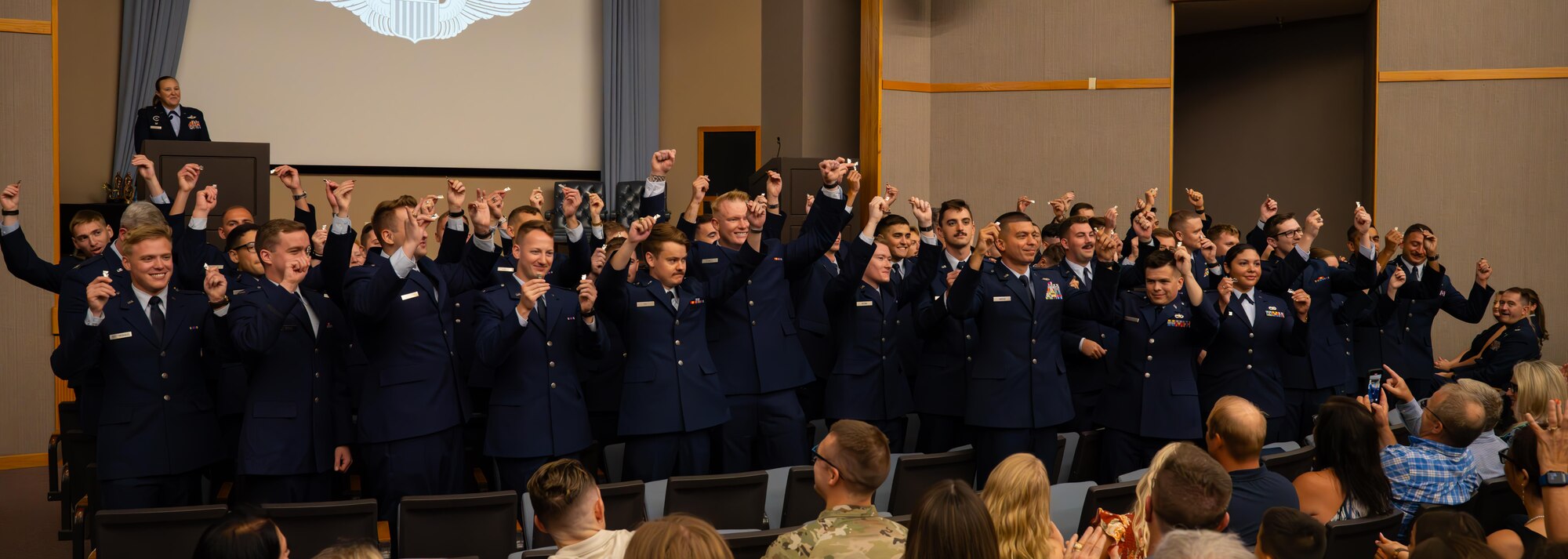 U.S. Air Force Airmen from graduating Class 24-15 break their wings at Laughlin Air Force Base, Texas, Sept. 20, 2024. Forty-nine U.S. Air Force officers were awarded silver wings during the ceremony, symbolizing their completion of the Undergraduate Pilot Training program. (U.S. Air Force photo by Airman 1st Class Harrison Sullivan)