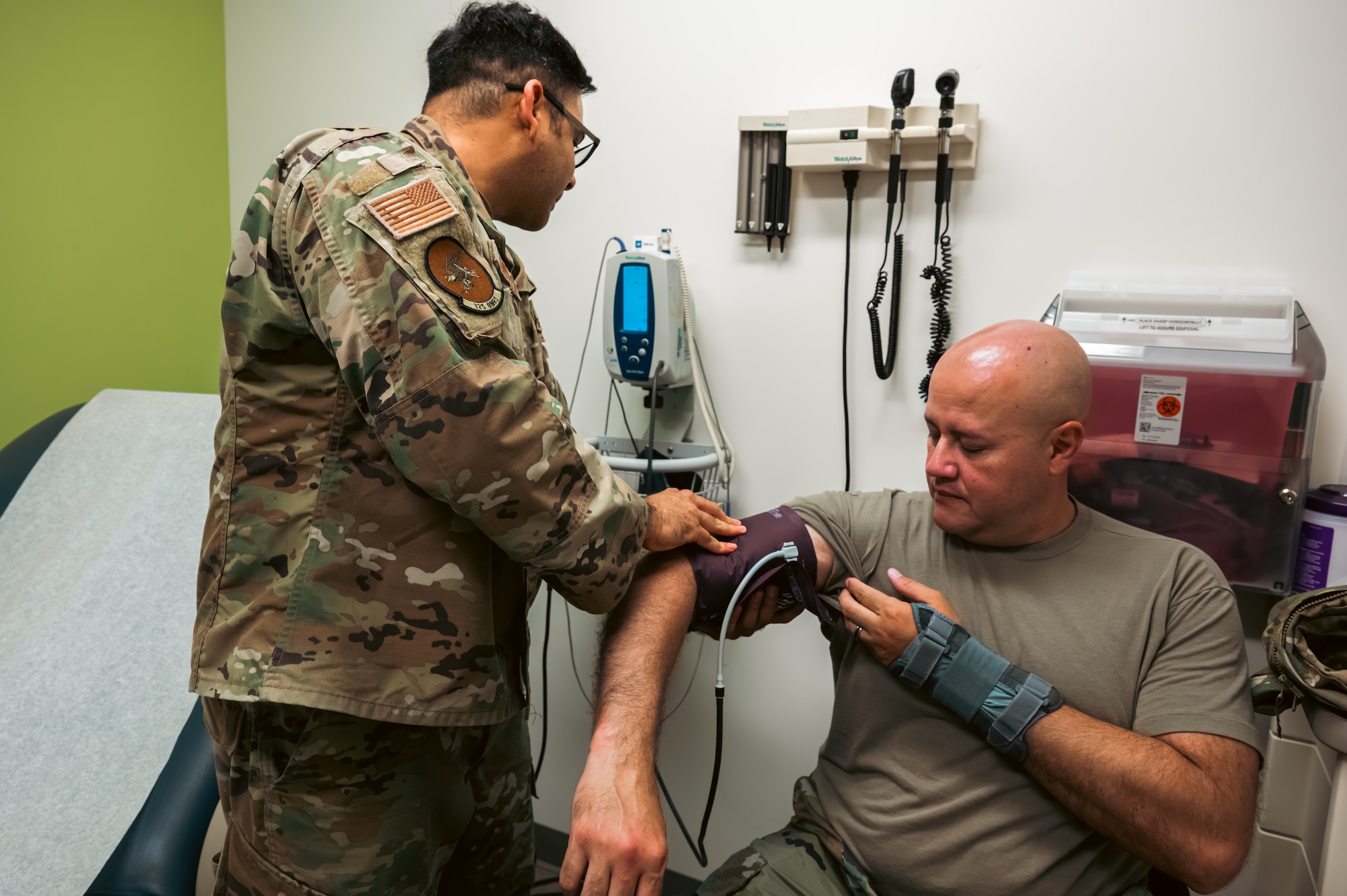 Airman from 325th OMRS checks another Airman's blood pressure for appointment