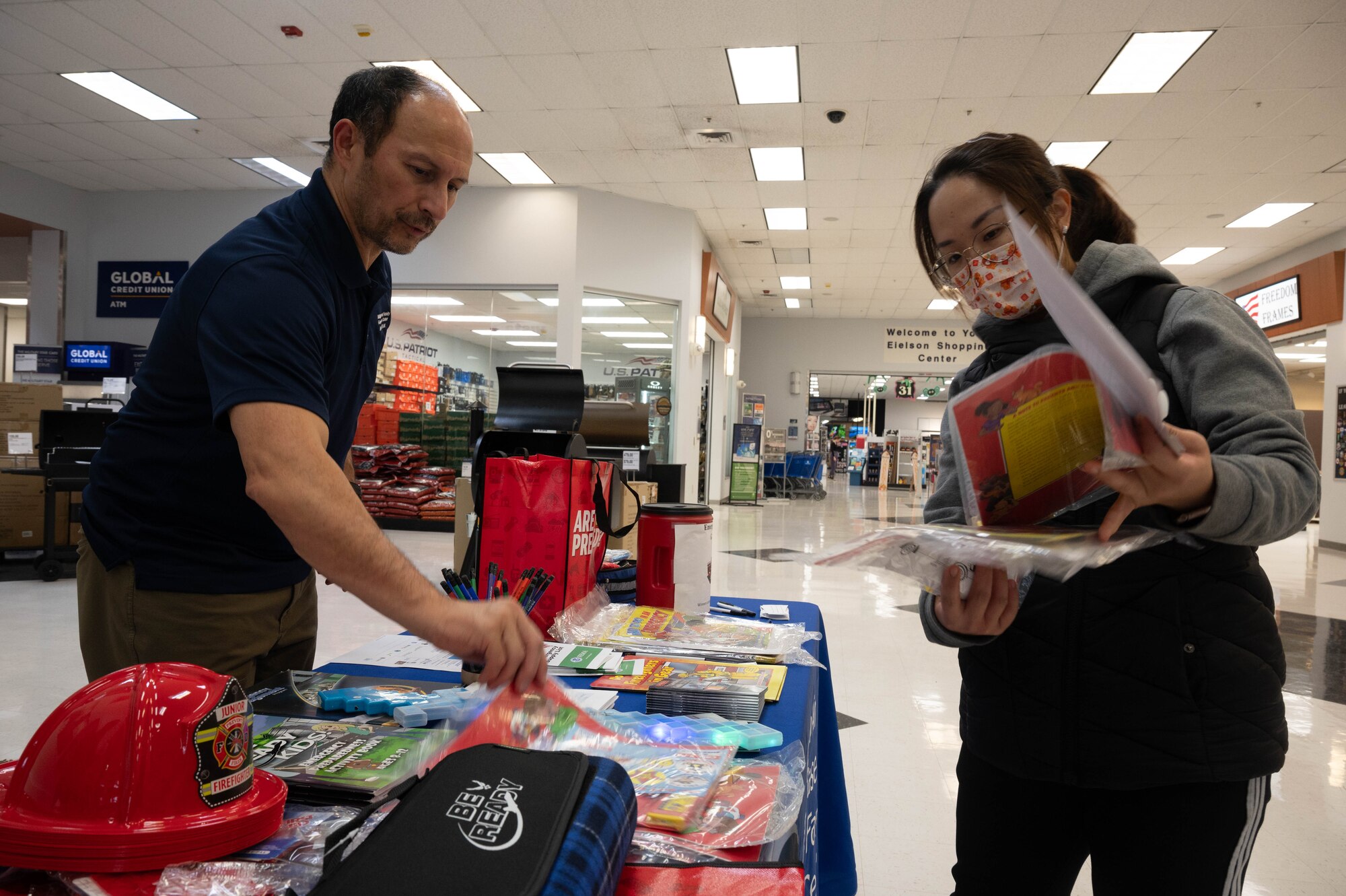 Kevin Francesco, Eielson Military & Family Readiness counselor, gives out information on disaster preparation to a base resident at Eielson Air Force Base, Alaska, Sept. 19, 2024.