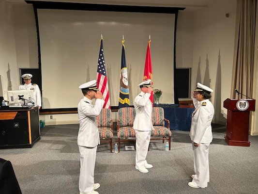 The Navy Bloodborne Infection Management Center (NBIMC) held a change of charge ceremony on August 23, 2024. During the ceremony Cmdr. Marshall Hoffman, Capt. Nimfa Teneza-Mora the outgoing officer in charge of NBIMC, salutes Capt. Marion Gregg, commander, Navy and Marine Corps Force Health Protection Command, and director, Defense Center for Public Health Portsmouth, center, presiding officer over the ceremony which was held at Naval Support Activity Bethesda, Maryland. Under Teneza-Mora leadership, the NBIMC maximized support for service members with positive test results, facilitated their expeditious notification and linkage to medical care and treatment, promoting these service members’ health, wellness, and expeditious return to full duty. (Navy courtesy photo by Mrs. Ashley Hoffman)