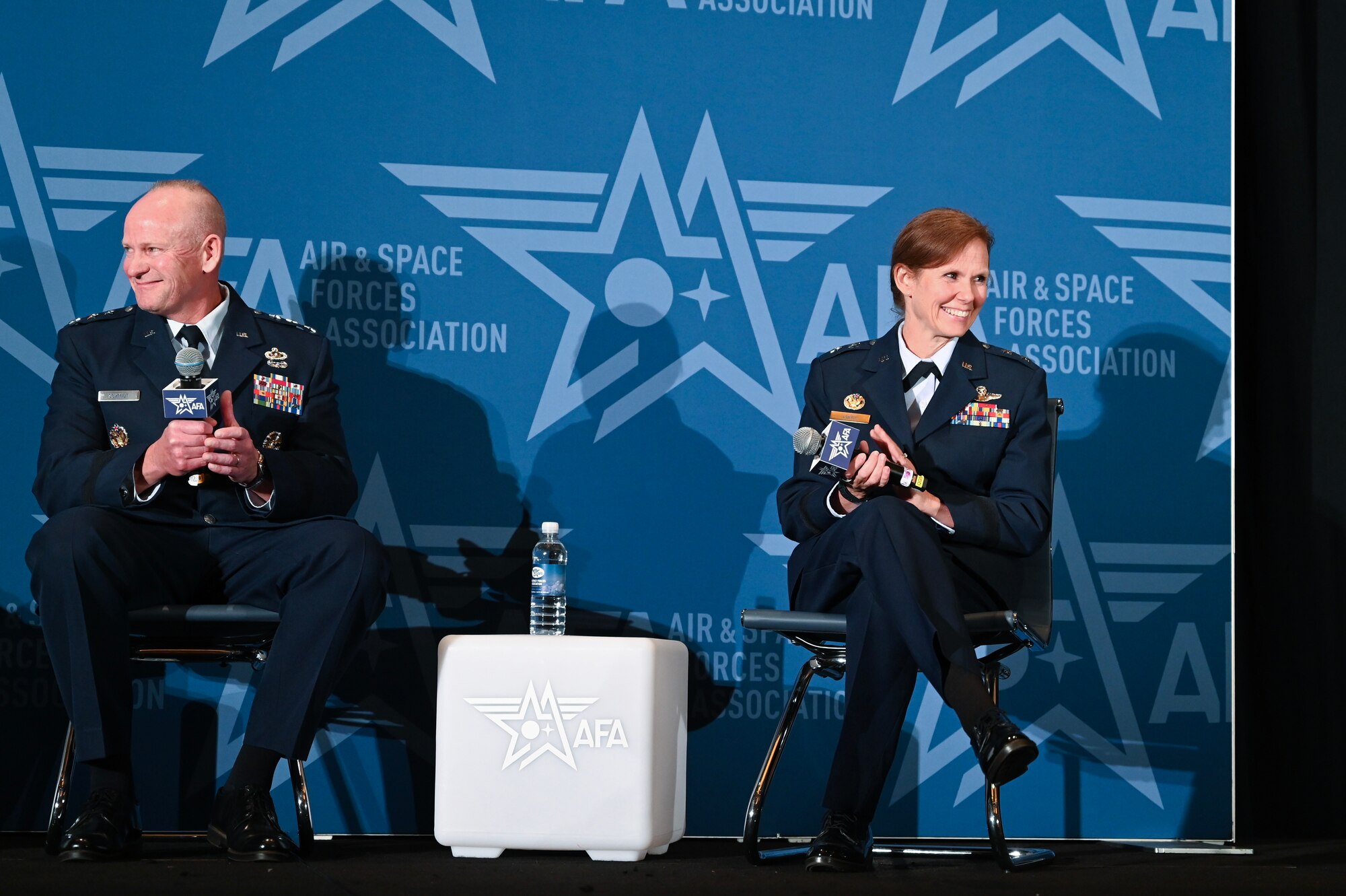 U.S. Air Force Lt. Gen. Michael Schmidt, F-35 Lightning II Program executive officer and director, and Maj. Gen. Regina Sabric, 10th Air Force commander, clap during an Air and Space Forces Association conference in National Harbor, Maryland, Sept. 17, 2024. The two spoke in a panel during a conference about the transition to the F-35 in the Air Force.
