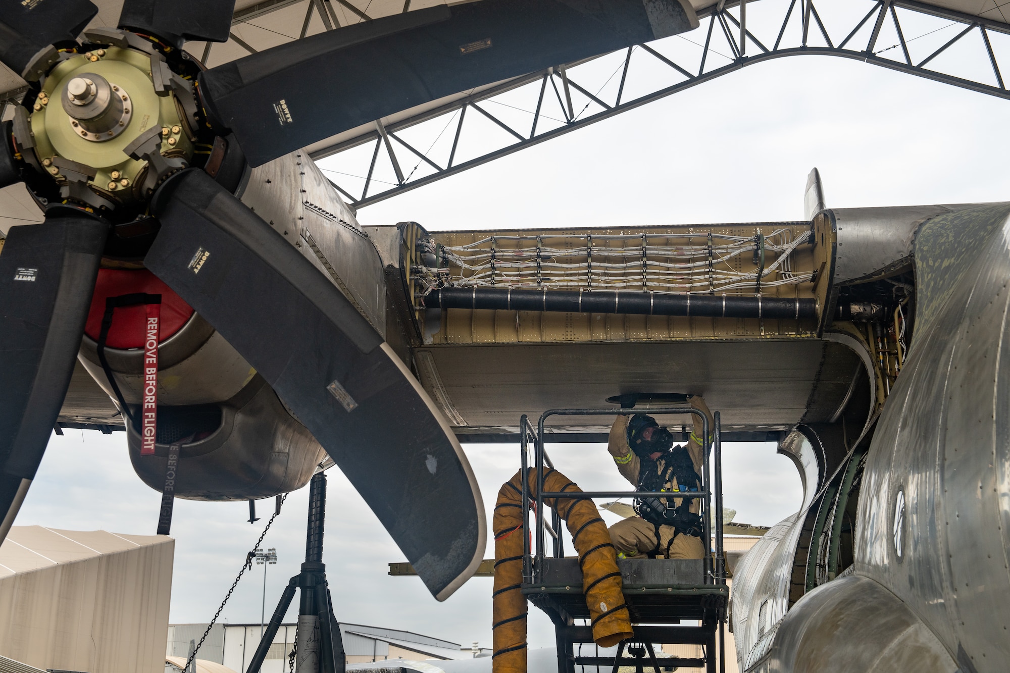 Firefighters retrieve a mannequin from a confined space in a C-130 wing cavity