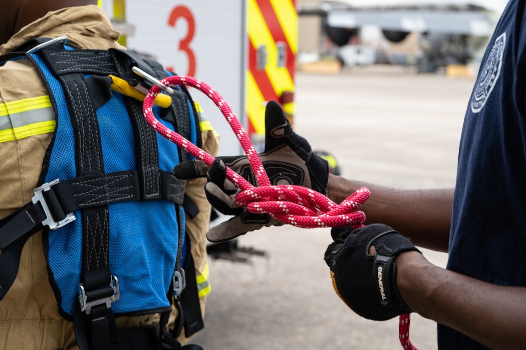 Firefighters tie knots to rig a harness