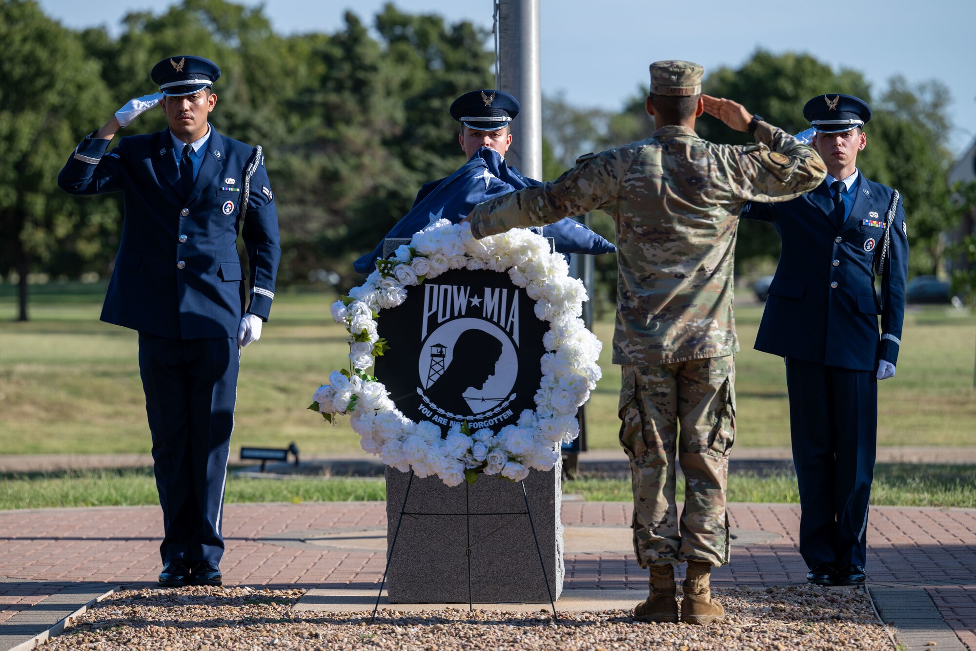 The 22nd Air Refueling Wing Honor Guard salutes the U.S. flag during the POW/MIA week opening ceremony at McConnell Air Force Base, Kansas, Sept. 16, 2024. The wreath laying ceremony reflects commitment to finding prisoners of war actively missing and recognizes the sacrifices made by those service members and their families. (U.S. Air Force photo by Airman 1st Class Paula Arce)