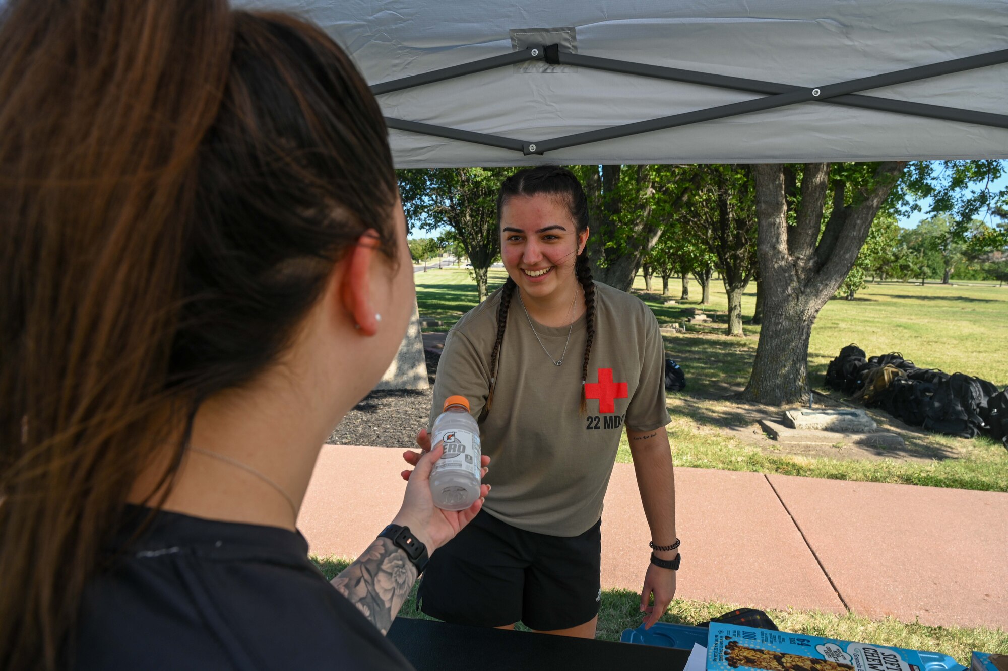 Senior Airman Raquel Kos, 22nd Medical Group medical technician, hands out beverages during the POW/MIA remembrance week 24-hour vigil walk/run Sept 18, 2024, at McConnell Air Force Base, Kansas. The week honors more than 81,500 U.S. service members who remain unaccounted for. (U.S. Air Force photo by Senior Airman William Lunn)