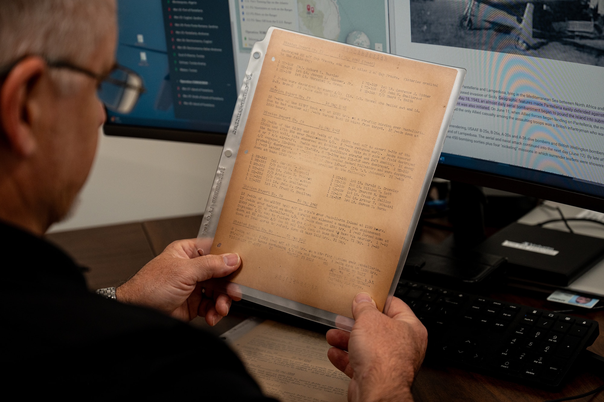Peter Coffman, 325th Fighter Wing historian, reads a World War II document at Tyndall Air Force Base