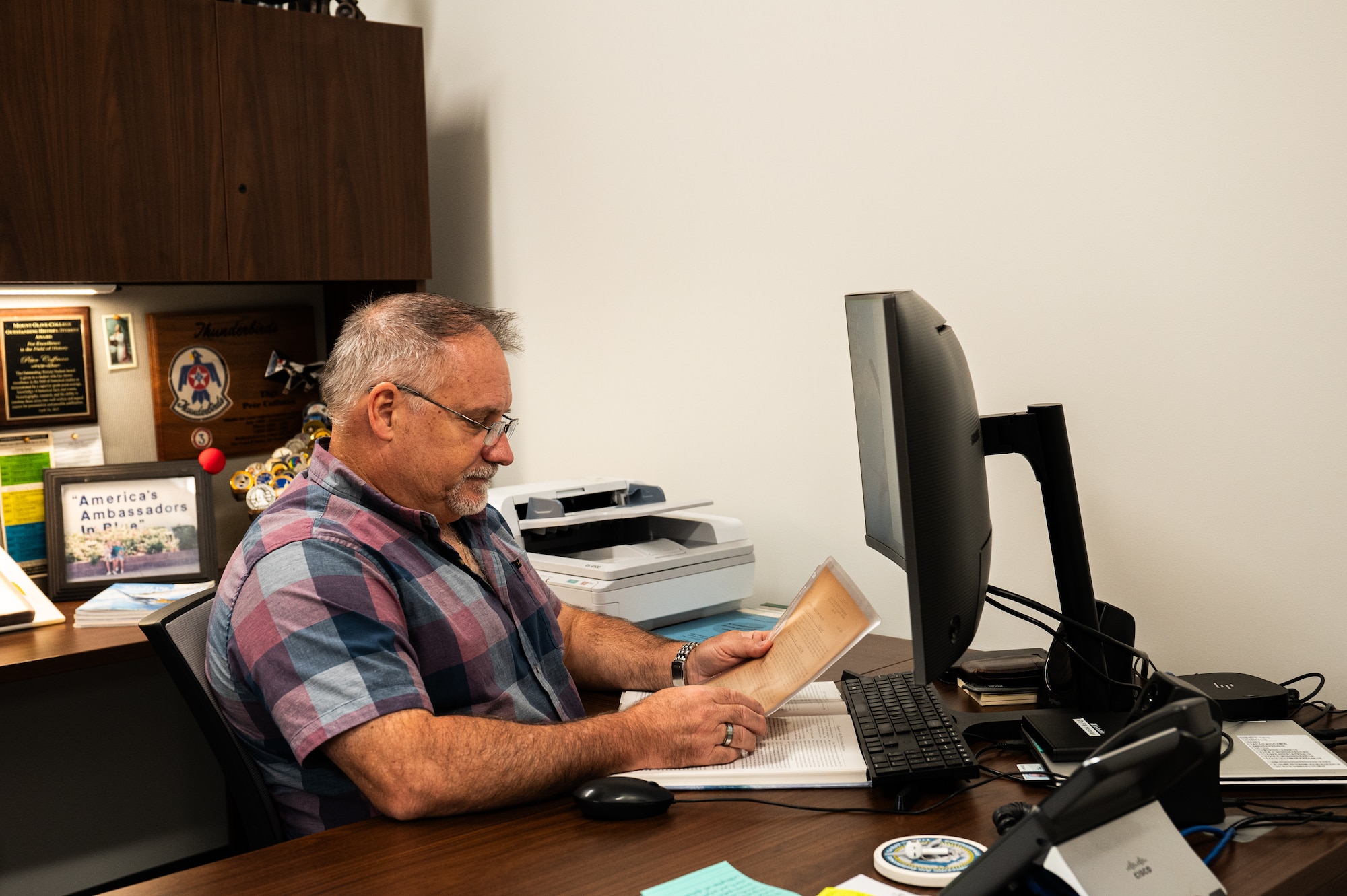 Peter Coffman, 325th Fighter Wing historian, looks over a World War II document at Tyndall Air Force Bas