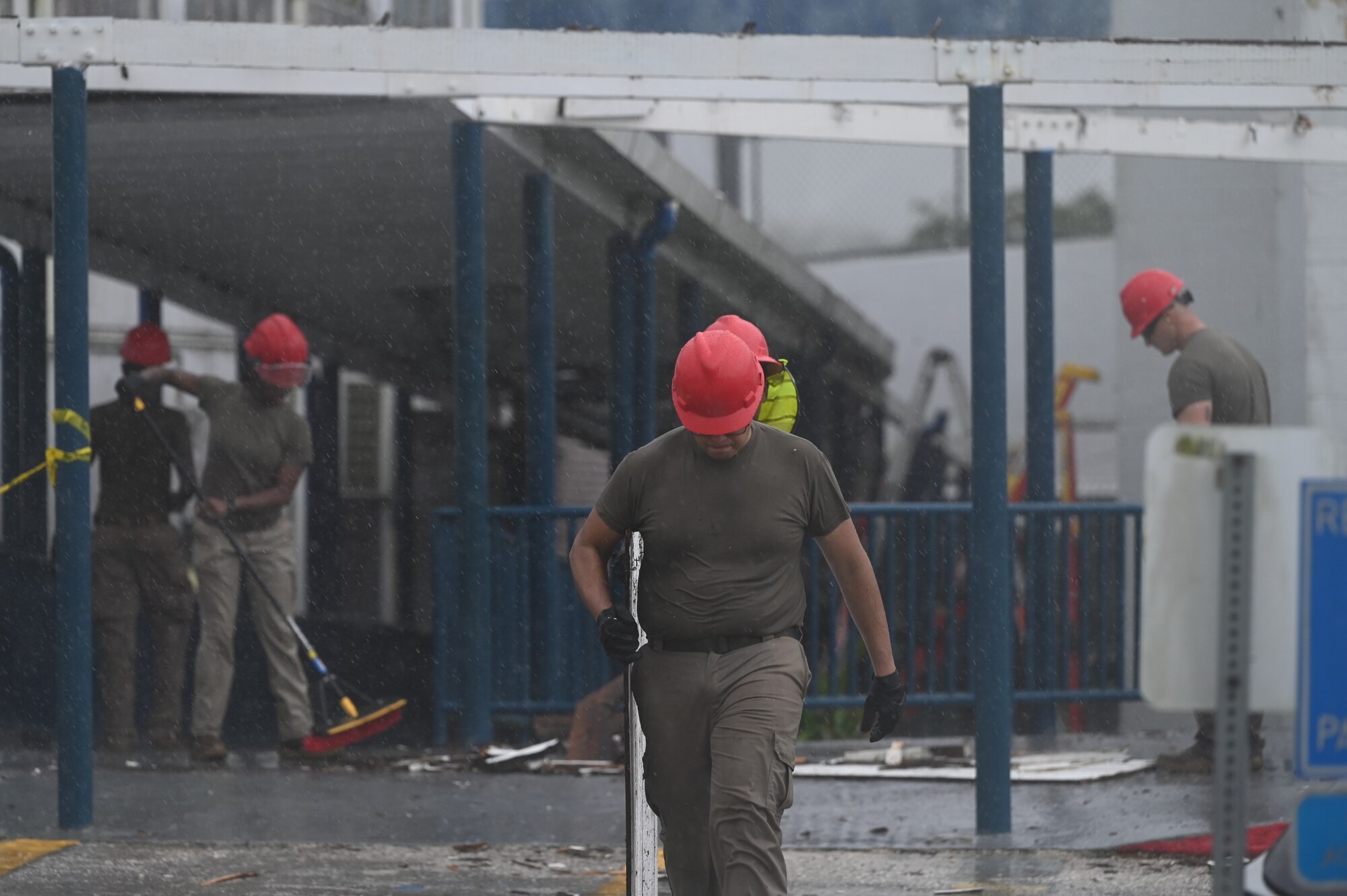 An Airman walks away from the walkway carrying disposable debris.