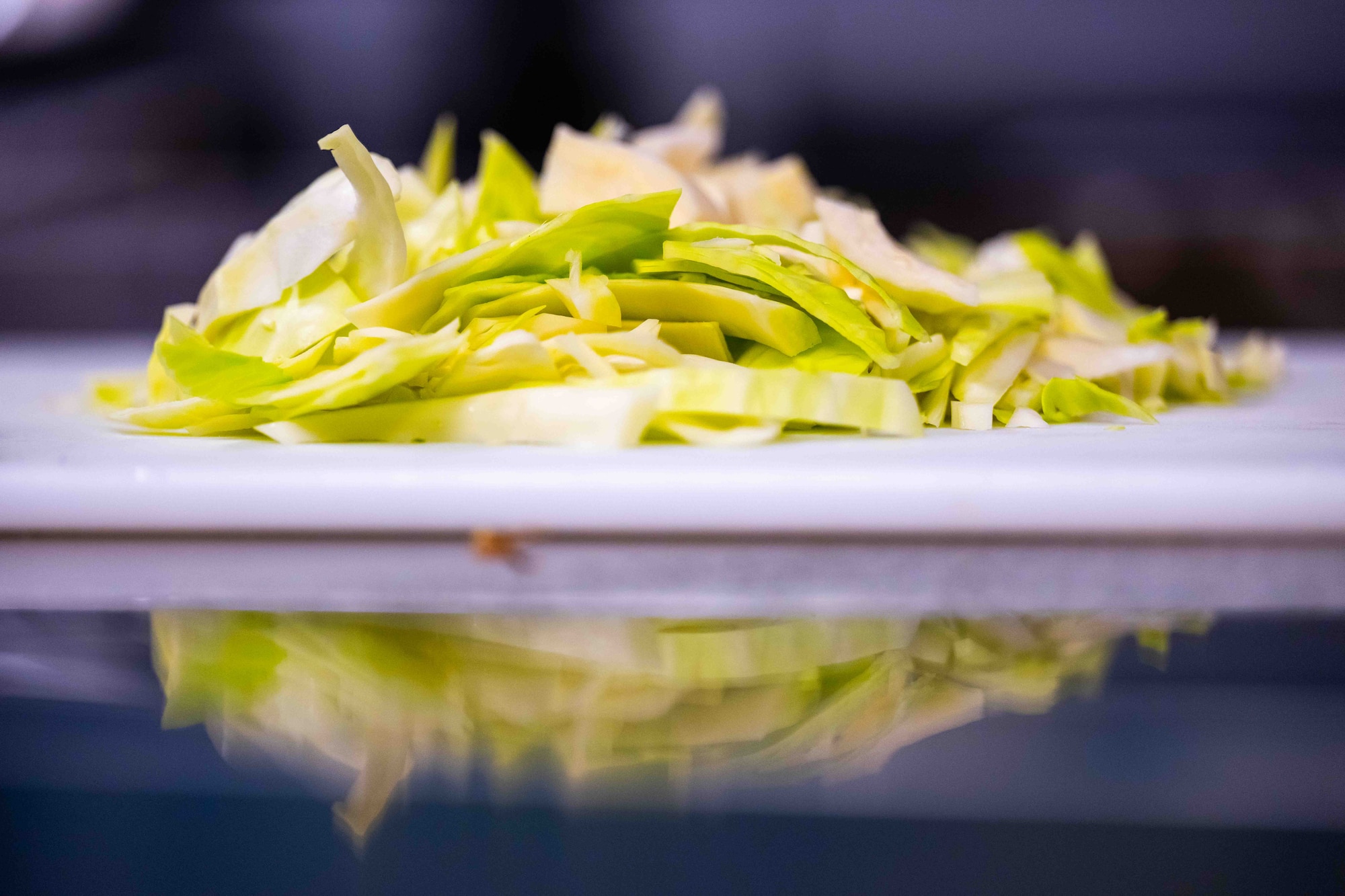 Sliced cabbage sits on a cutting board.