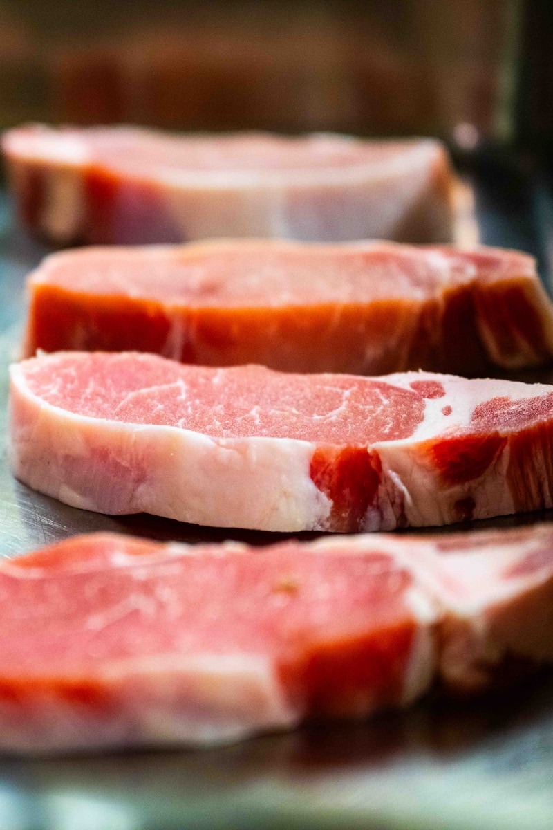 Raw steak is placed on a cooking pan.