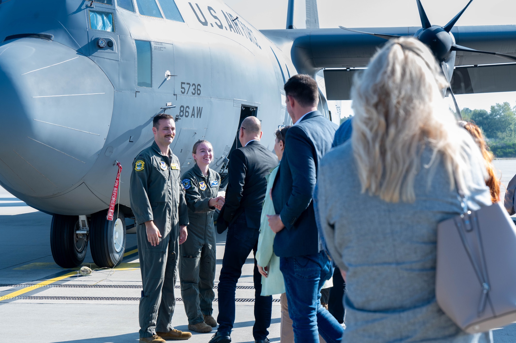 People interact next to an aircraft