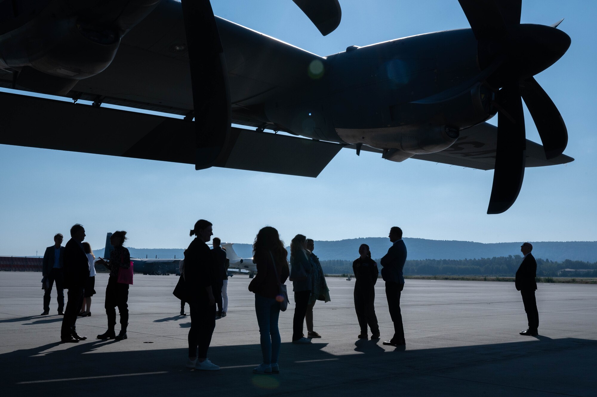 People stand under the wing of an aircraft