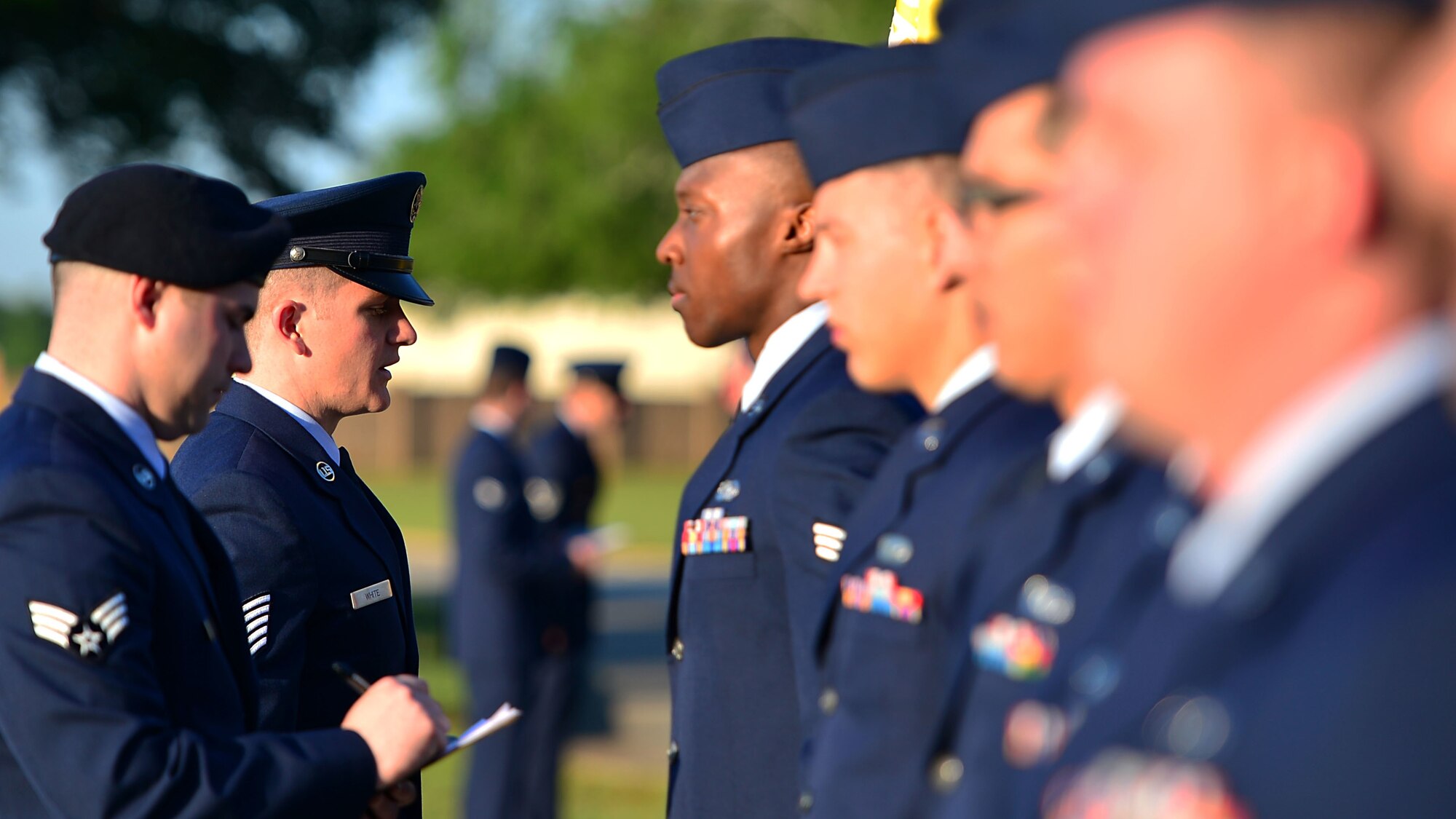 Airmen in dress uniform undergoing inspection