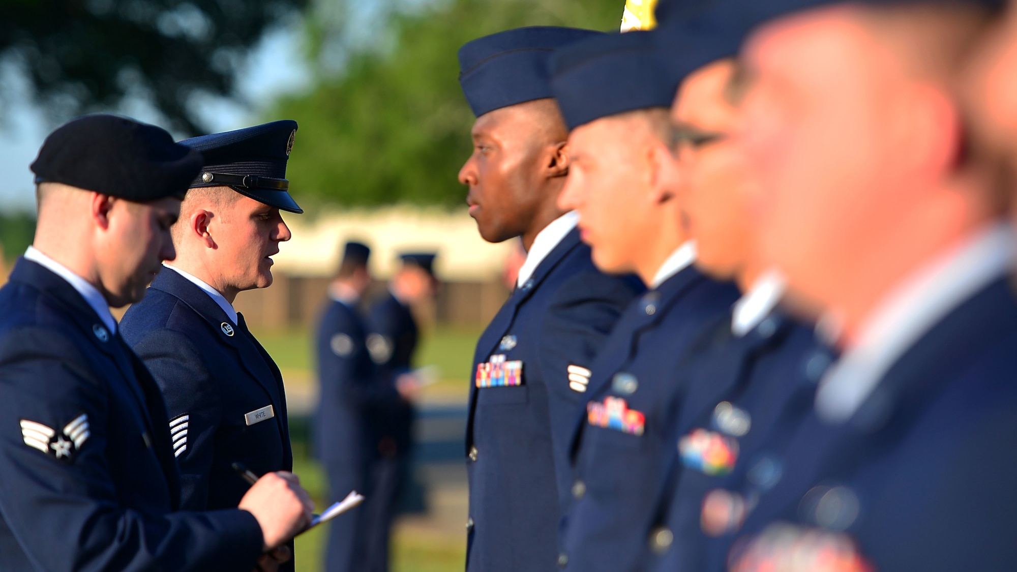 Airmen in dress uniform undergoing inspection