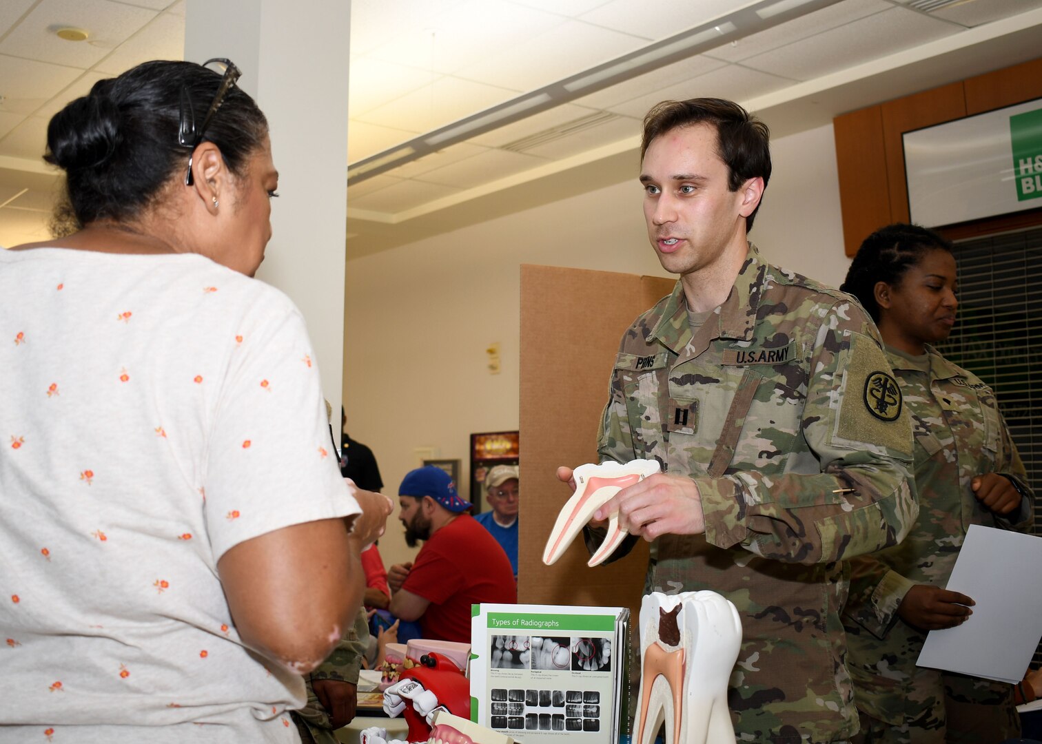 Capt. Ian N. Prins, an endodontist with the Dental Health Activity – Fort Drum, provides dental health information to a retiree during the Fort Drum Retiree Appreciation Day at Fort Drum, N.Y., Sept. 21, 2024.