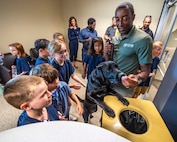 NCIS Special Agent David Lawhorn and Electronic Storage Detection K9 Jill demonstrate search techniques to children of NCIS employees.