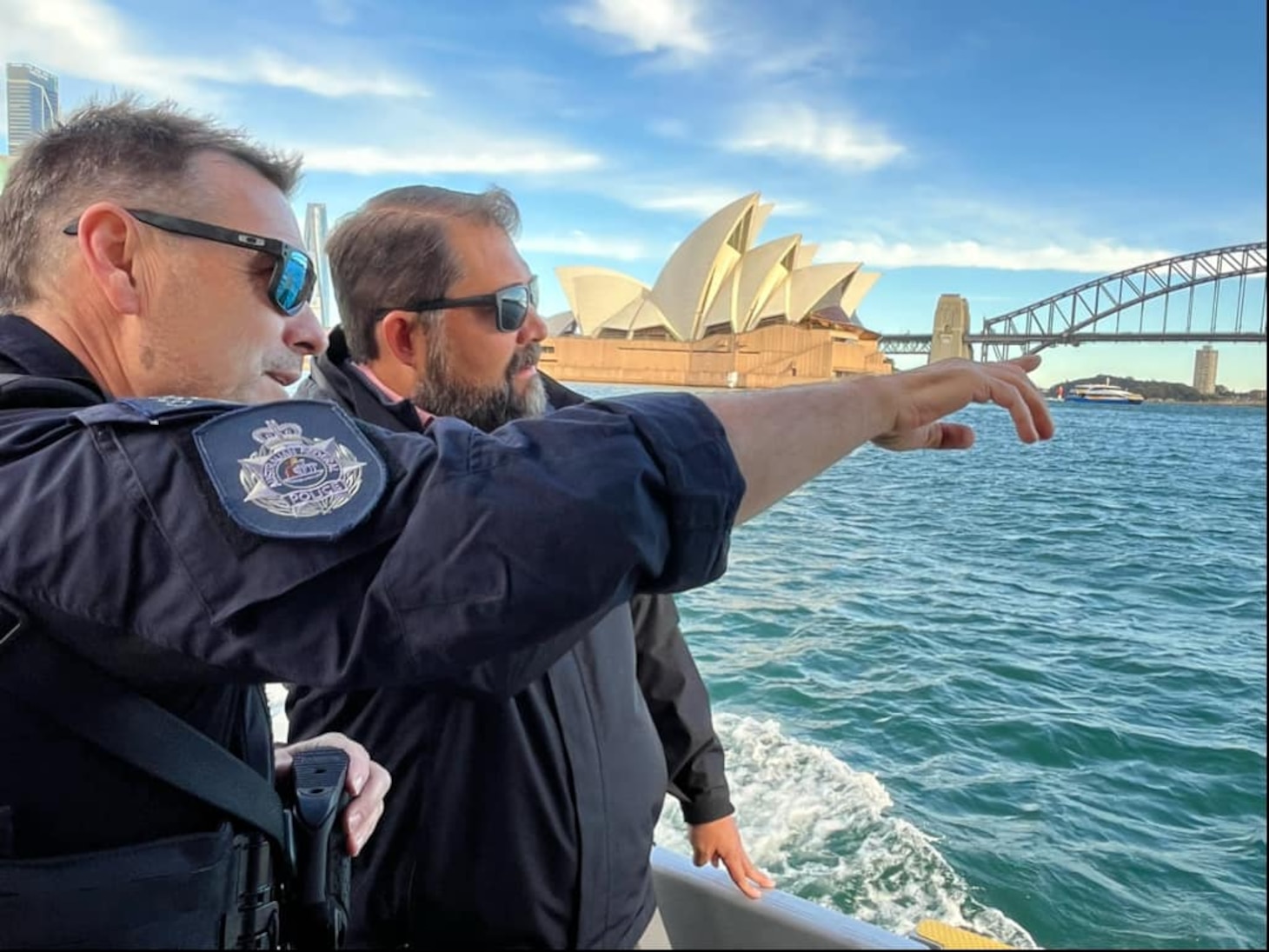 Director Lopez speaks with members of the Australian Federal Police aboard a vessel in the Australian waters. Sydey Opera House is displayed in the distant background.