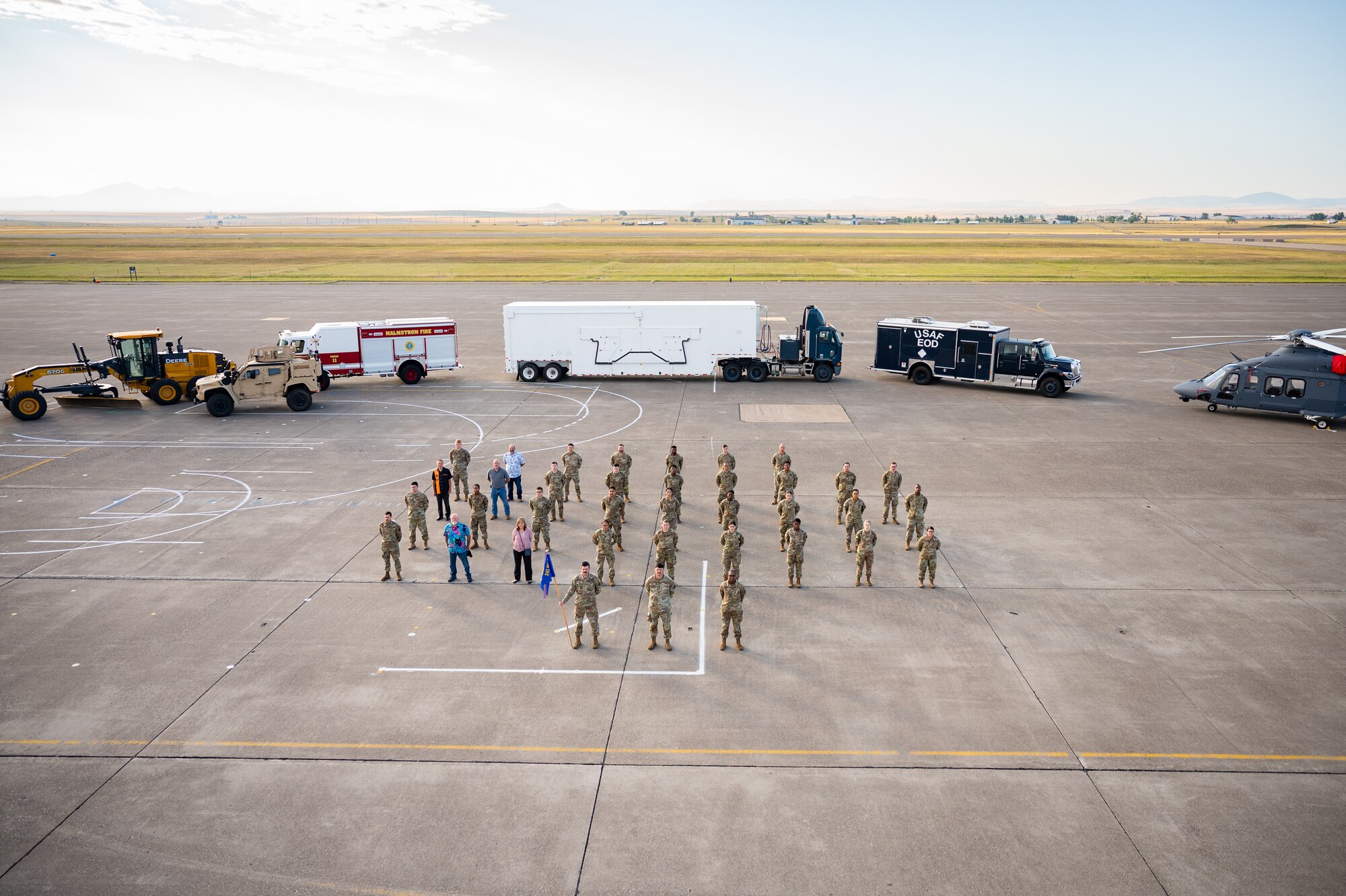 A group of uniformed personnel stand together for a photo.
