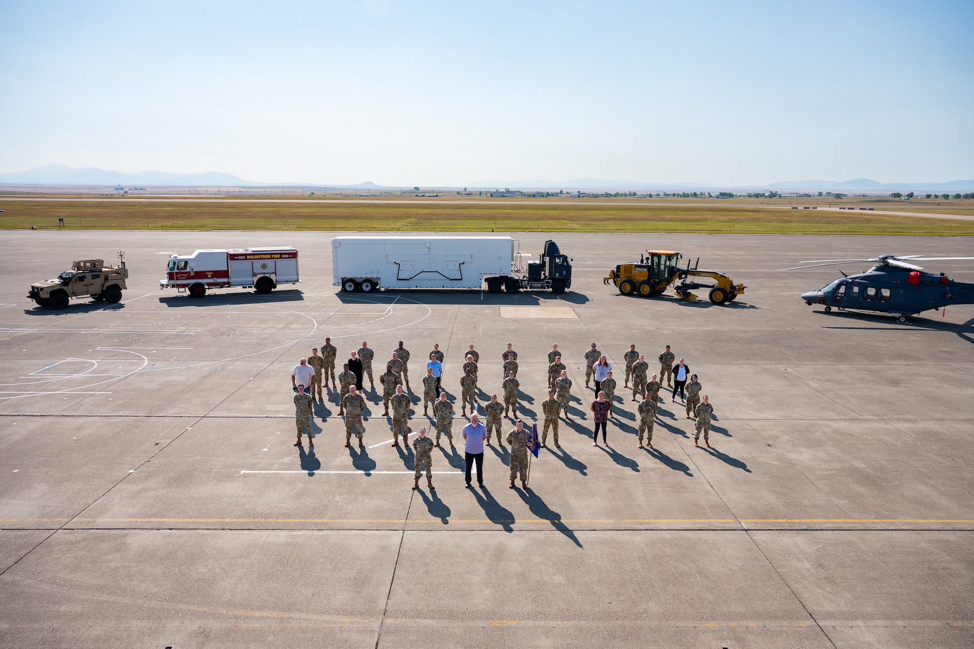 A group of uniformed personnel stand together for a photo.