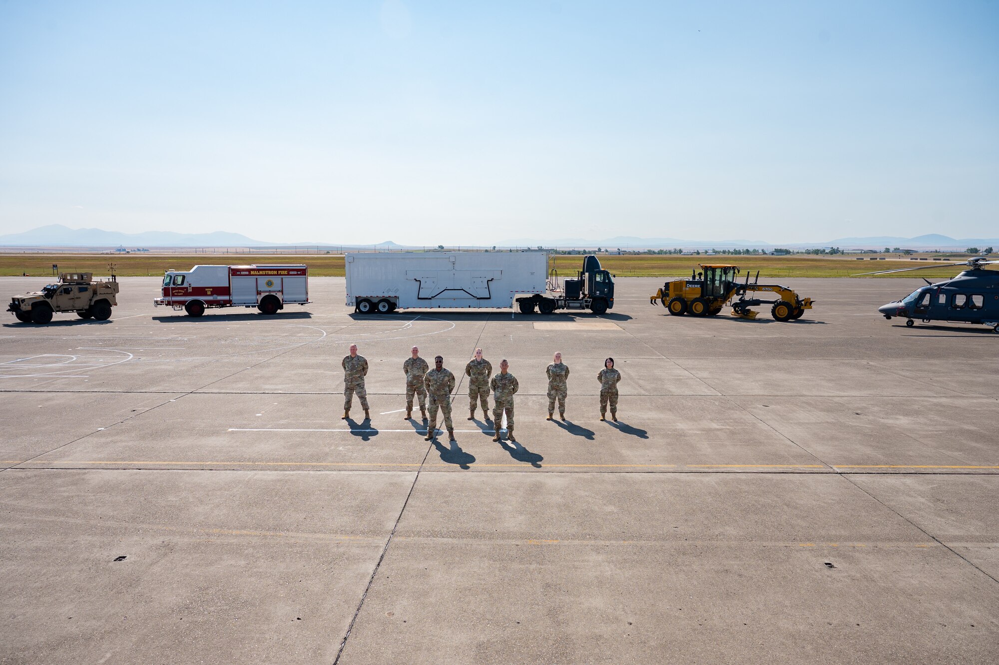 A group of uniformed personnel stand together for a photo.