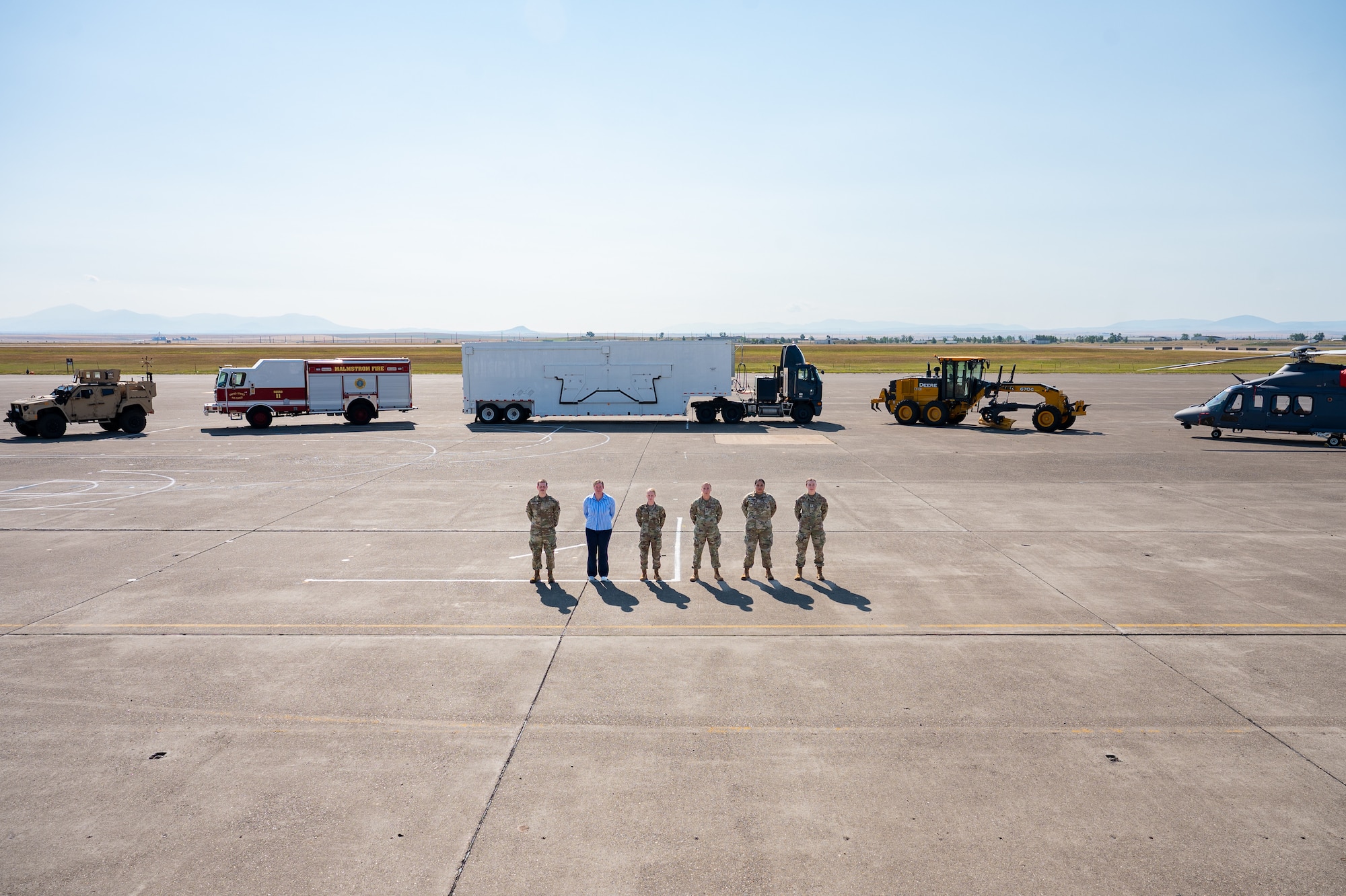 A group of uniformed personnel stand together for a photo.