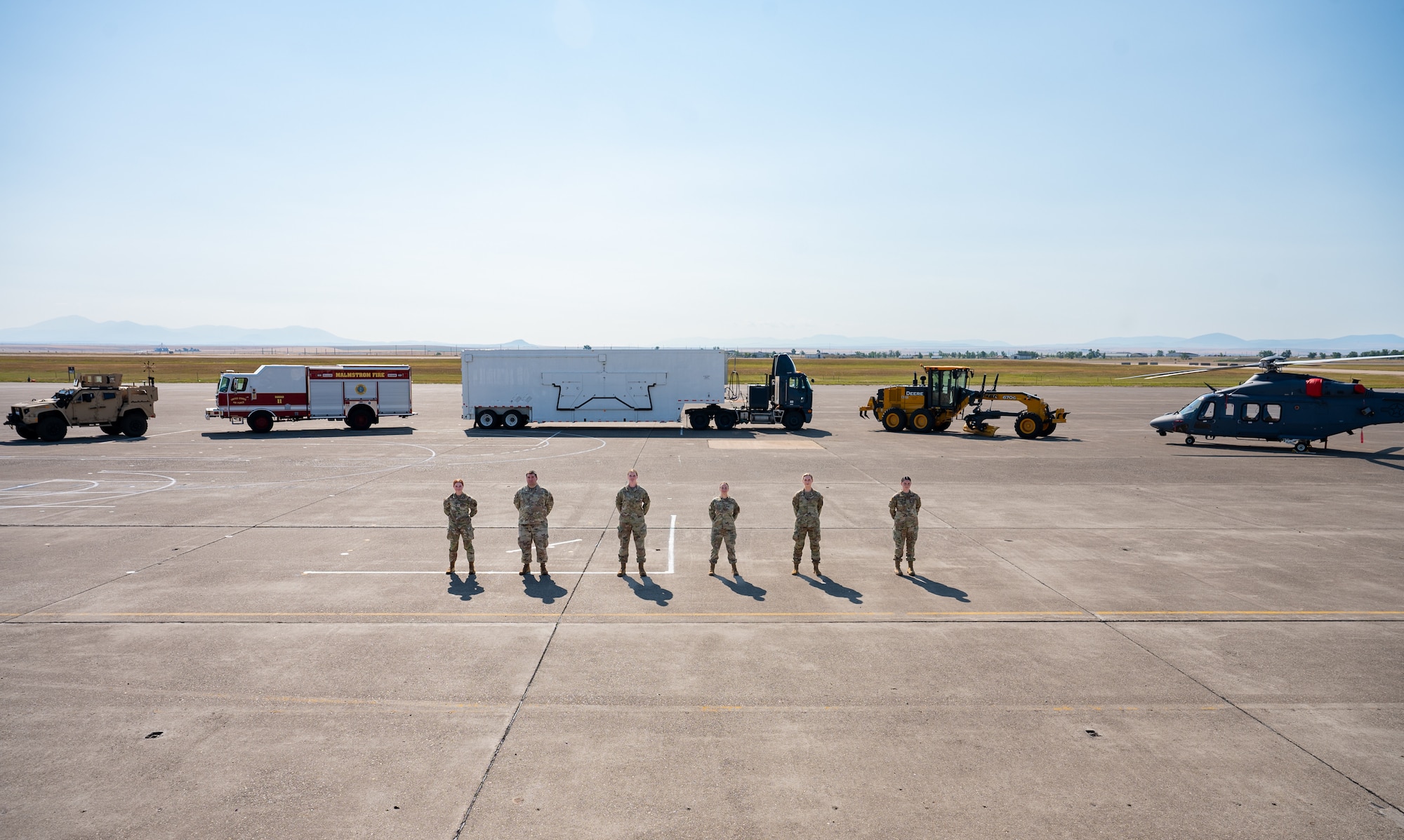A group of uniformed personnel stand together for a photo.