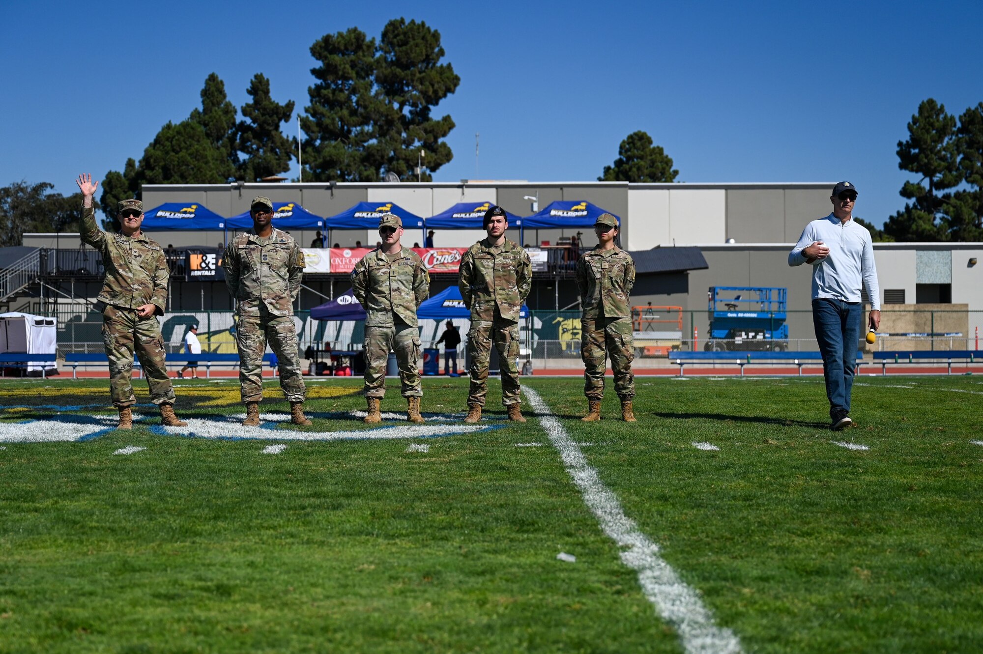 A Space Launch Delta 30 commander, left, waves to the crowd alongside a SLD 30 senior enlisted leader, right, during the 21st Annual Military Appreciation game at Allan Hancock College in Santa Maria, Calif.