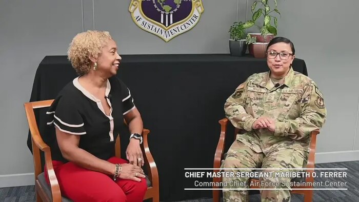 Civilian and military personnel sit for an interview.