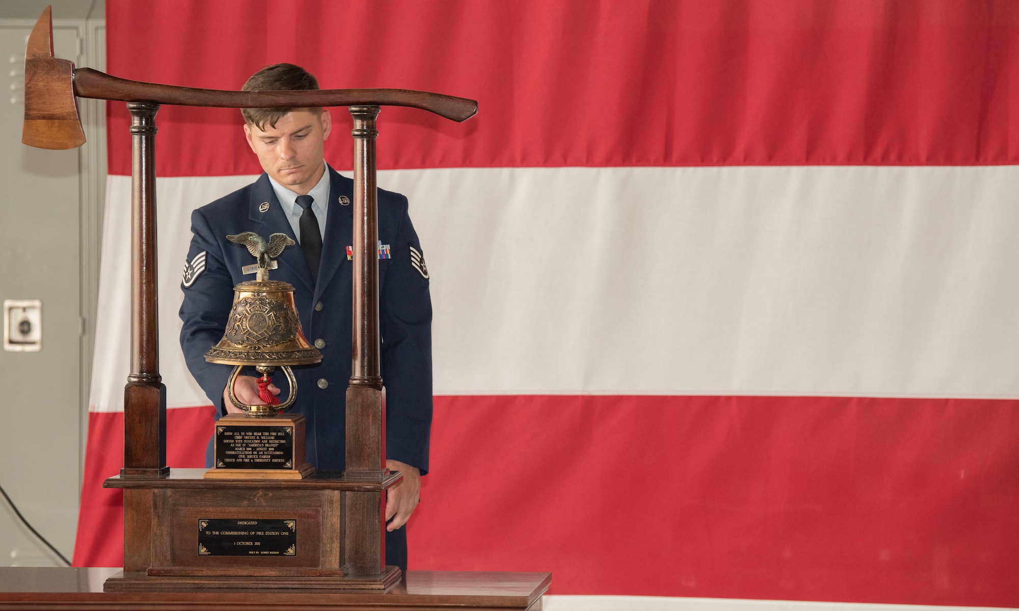 A firefighter rings a bell
