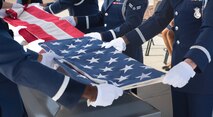 Airmen demonstrate the folding of the flag during an Honor Guard graduation ceremony