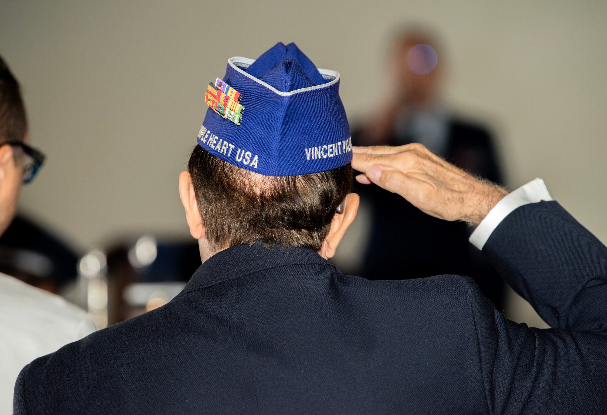 A veteran holds a salute during a National Prisoner of War and Missing in Action (POW/MIA) recognition ceremony
