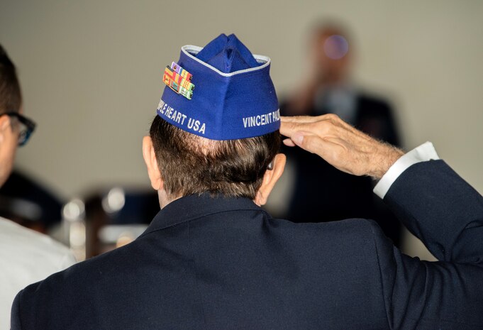 A veteran holds a salute during a National Prisoner of War and Missing in Action (POW/MIA) recognition ceremony