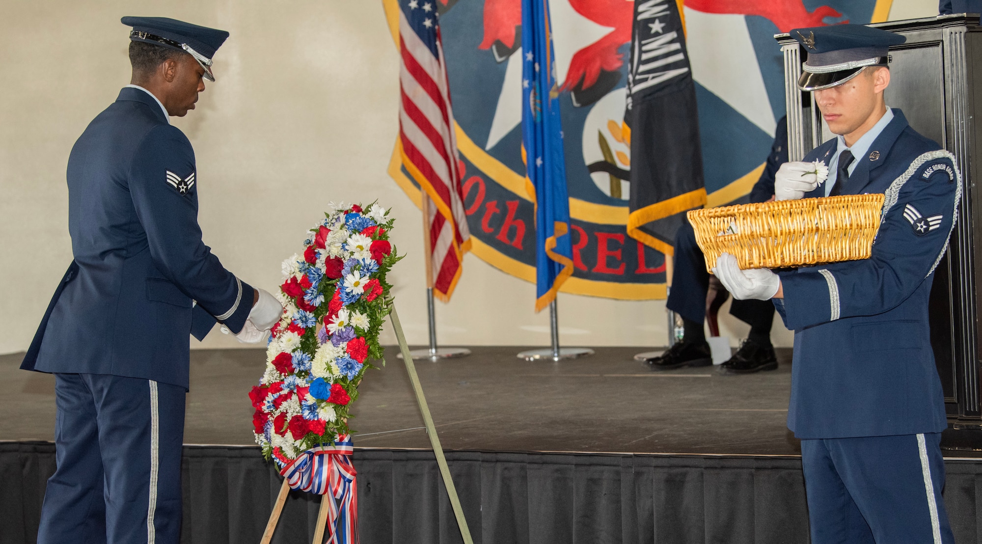 Honor Guard airmen put flowers on a memorial wreath during the memorial wreath dedication and remembrance ceremony