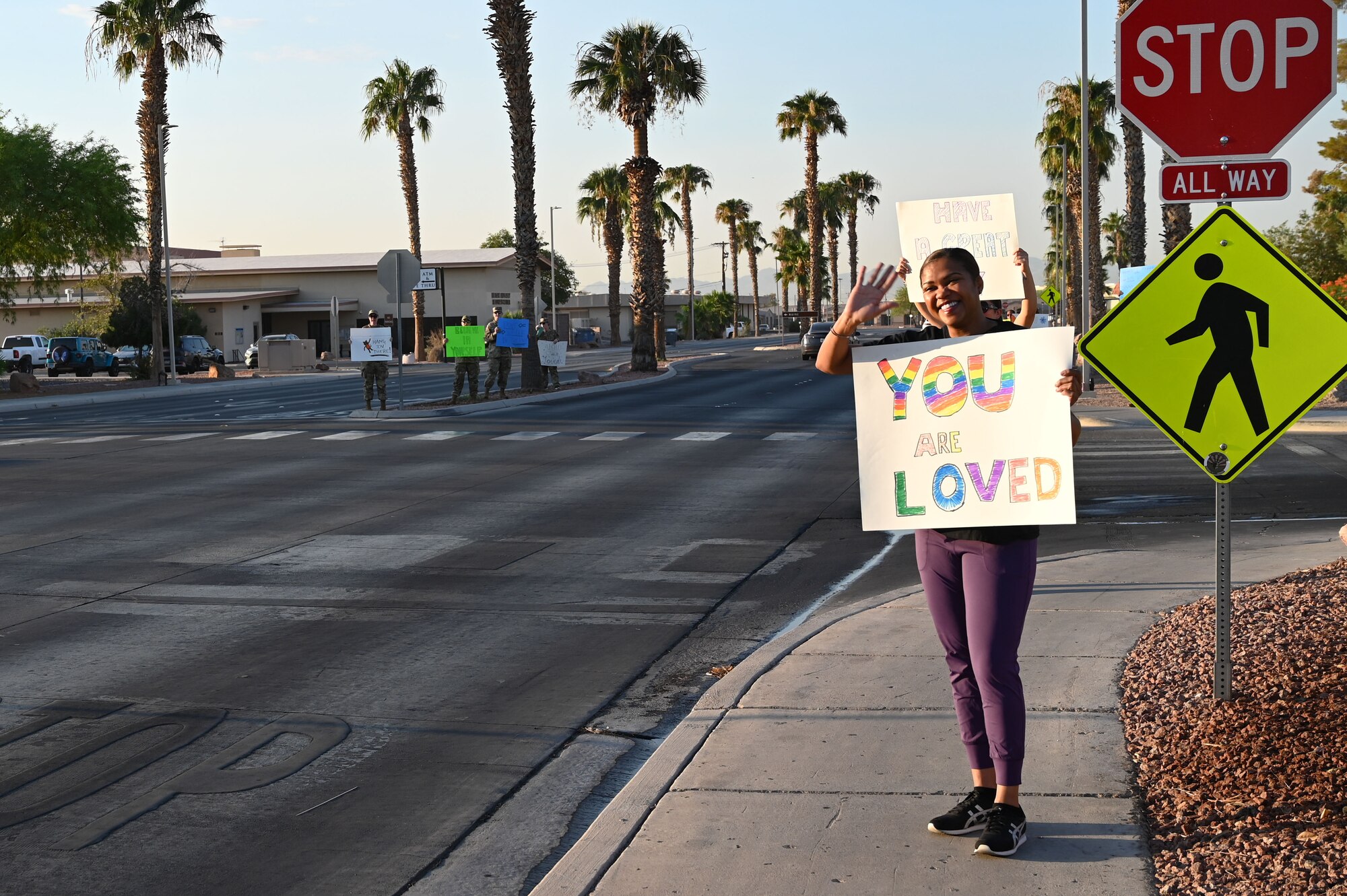 Chief Master Sgt. Adrienne Warren, the 99th Air Base Wing command chief greets drivers during a Suicide Prevention Awareness Month