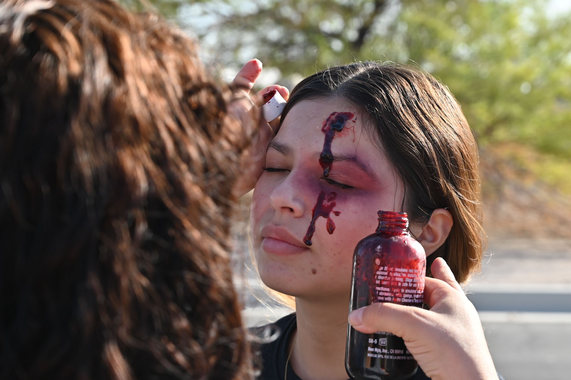 An Airman has special effects applied to her during an exercise