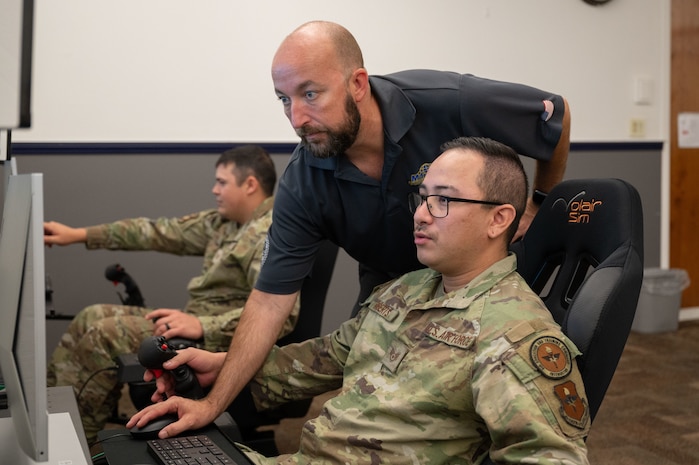 Three people using an aircraft simulator