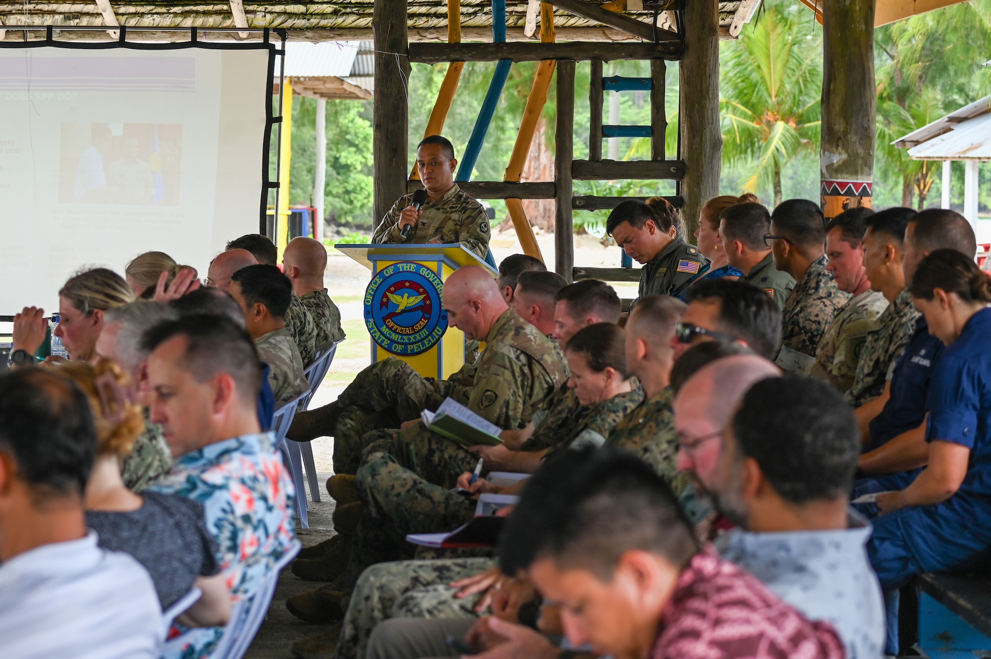U.S. Army Col. Manny Duenas, Guam National Guard State Partnership Program director, addresses the members of the 2024 Mid-Joint Committee meeting at Peleliu South Dock, Republic of Palau, Sept. 17, 2024. Duenas discussed the new partnership with Palau and how the Guam Guard would be able to support Palau. (U.S. Air Force photo by Airman 1st Class Natasha Ninete).