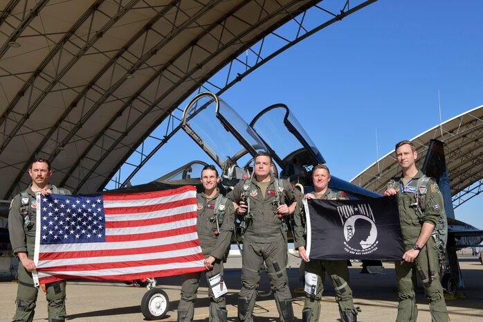 U.S. Air Force 1st Reconnaissance Squadron pilots pose with the U.S. and POW/MIA flag in front of a T-38 Talon at Beale Air Force Base, California, Sept 11, 2024.