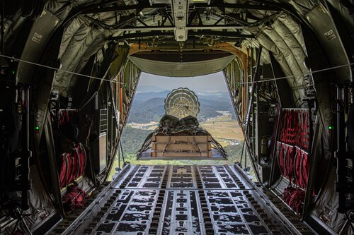 Large cargo exiting the back of an aircraft during flight