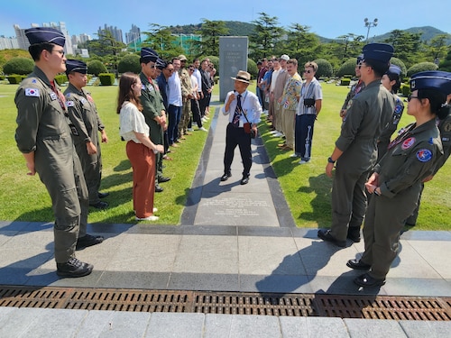 A group of US and ROK Air Force members around a monument at the United Nations Memorial Cemetery